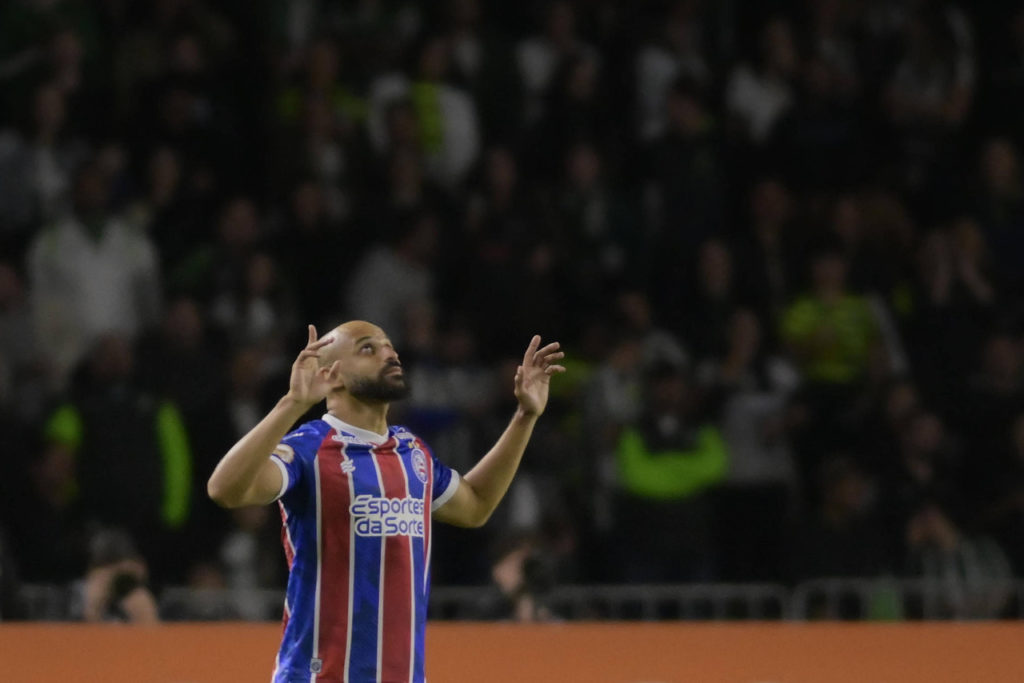 Thaciano, do Bahia, levanta as mãos pra o céu, ao comemorar um gol durante uma partida de seu clube.