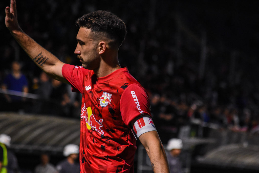 Léo Ortiz, zagueiro do Red Bull Bragantino, observa e aponta para um adversário durante uma partida do clube.