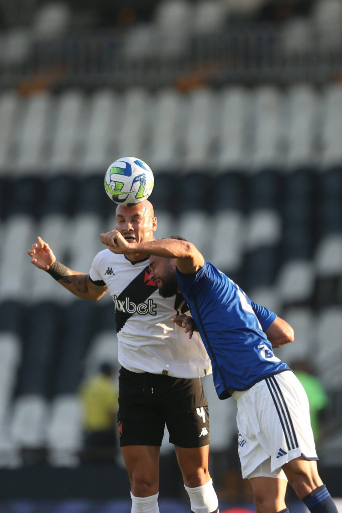 Maicon, zagueiro do Vasco, disputa uma bola com um colega de profissão durante uma partida contra o Cruzeiro.