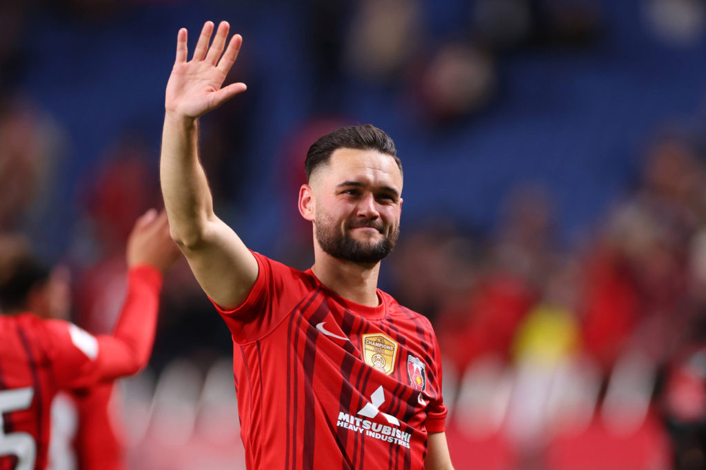 Alex Schalk, atacante do Urawa Reds, acena com a mão durante um jogo do time.