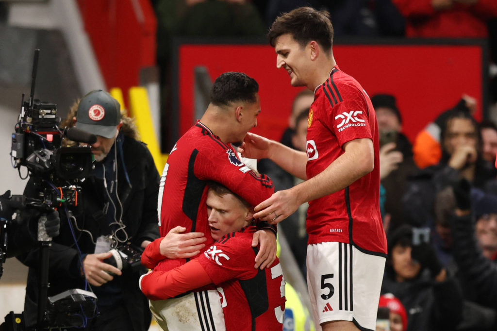 Jogadores do Manchester United se abraçam ao comemorar um gol do time.