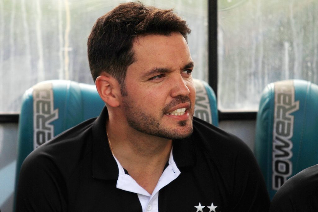 Nicolás Larcamón, do Cruzeiro, venstindo a camisa de outro clube e observando o time.