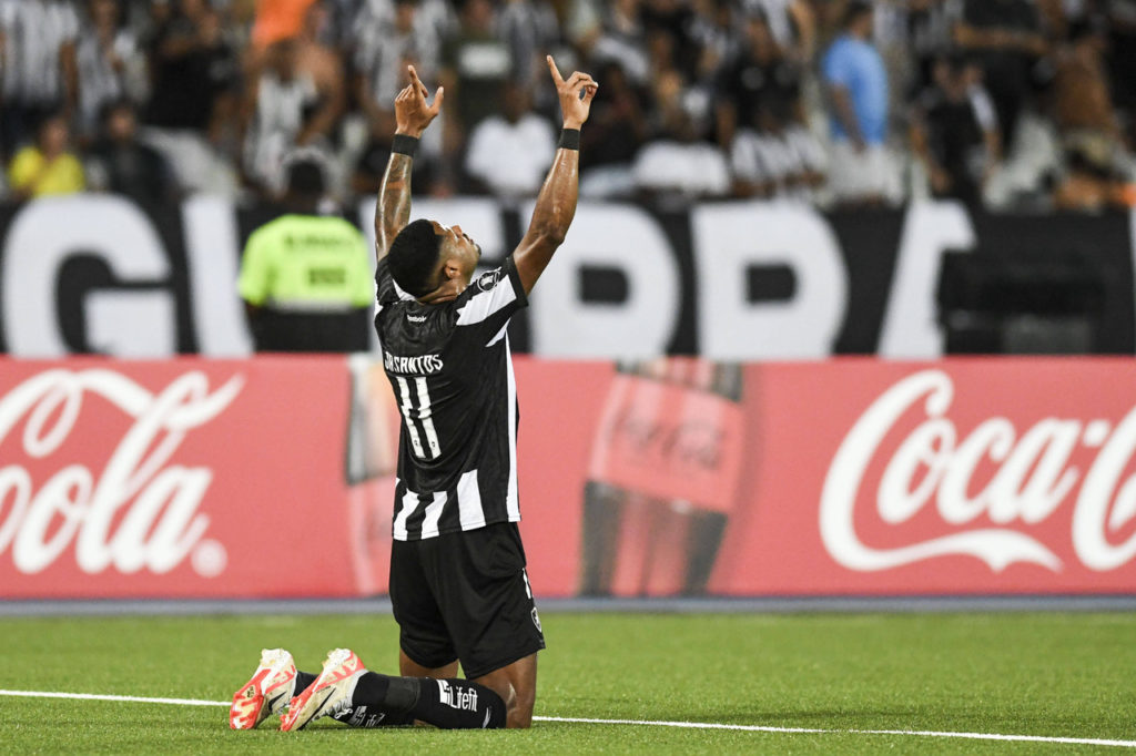 Júnior Santos, do Botafogo, ajoelhado, comemorando um dos gols marcados pelo time na Libertadores.