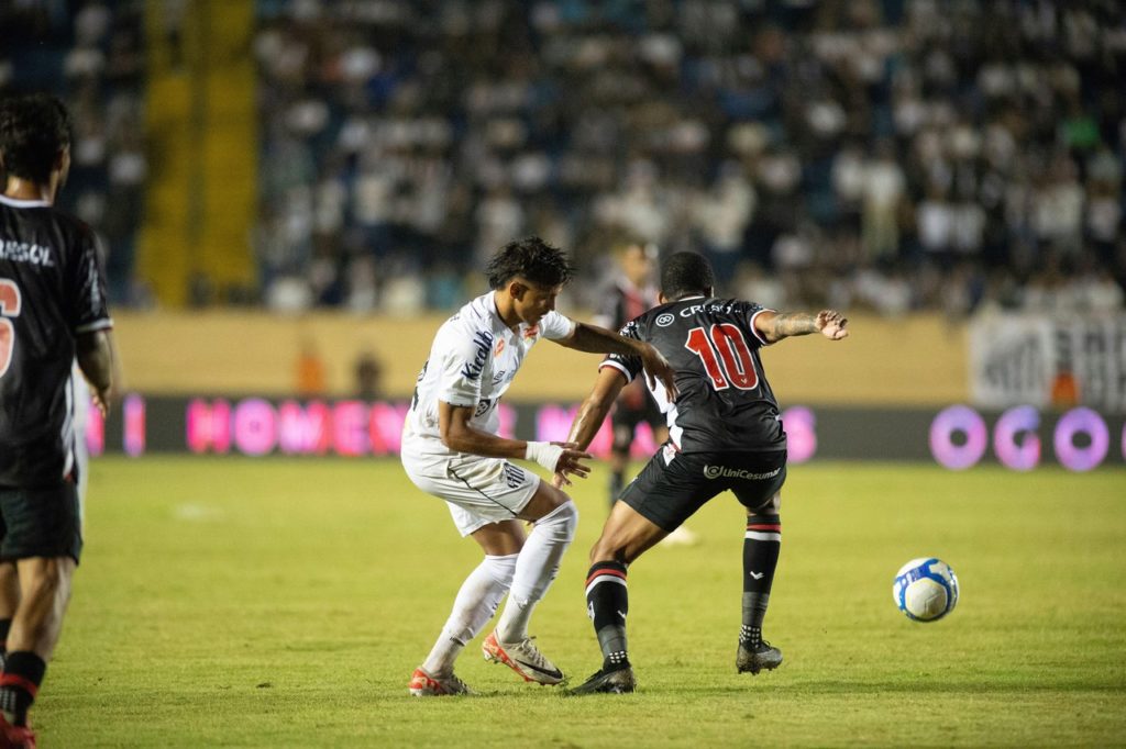 Gustavo Bochecha, do Botafogo-SP, tenta sair jogando, mesmo marcado, em um jogo do time pelo Brasileirão Série B.