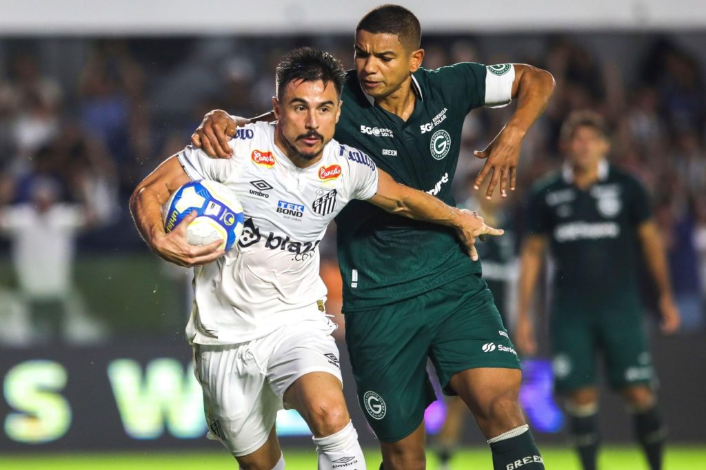 Willian Bigode, do Santos, disputa a bola com David Braz, do Goiás, em um jogo entre as duas equipes na temporada de 2024.