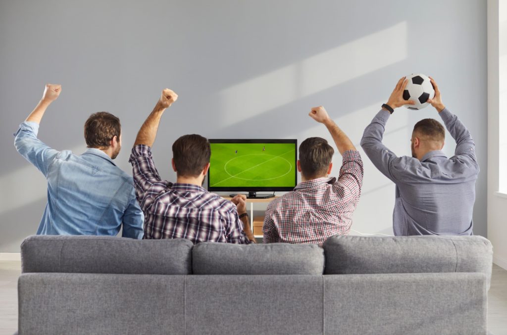 Adeptos a assistir uma partida de futebol na TV (Roman Lacheev / Alamy Stock Photo)