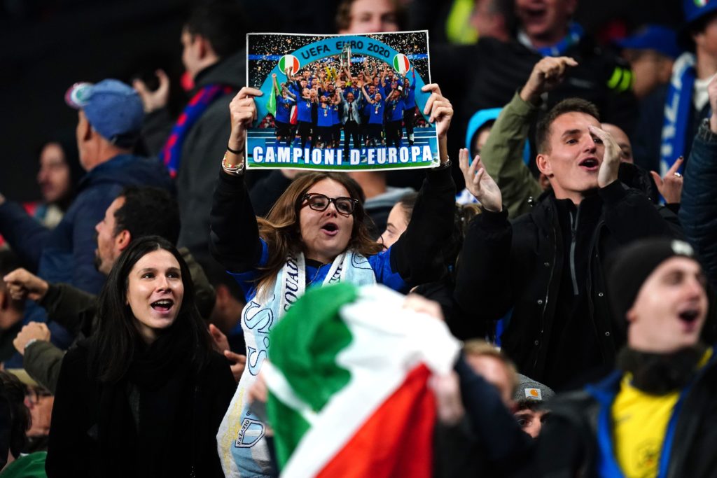 Torcedores da Itália seguram uma foto da seleção italiana vencendo a final do UEFA Euro 2020 contra a Inglaterra, durante a partida de qualificação para o UEFA Euro 2024, no Estádio de Wembley, em Londres.
