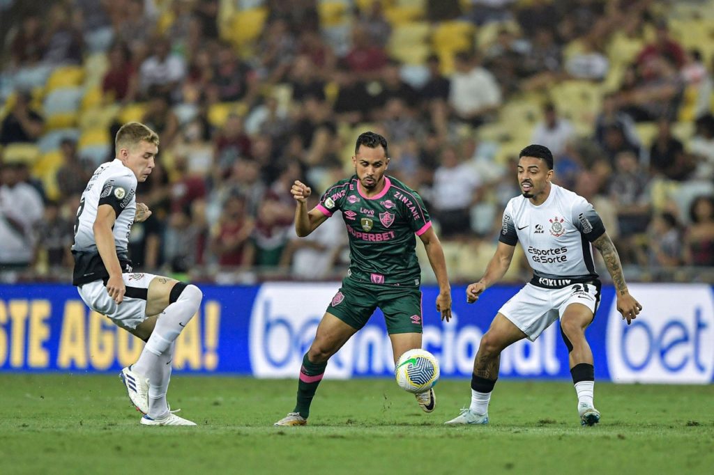 Lima, do Fluminense, disputando a bola com dois marcadores do Corinthians.