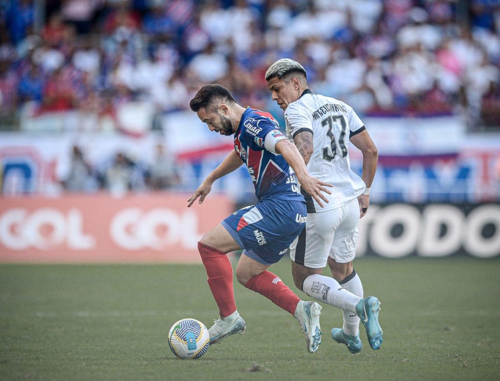 Everton Ribeiro, do Bahia, disputando a bola com um adversário em um jogo pelo Campeonato Brasileiro.